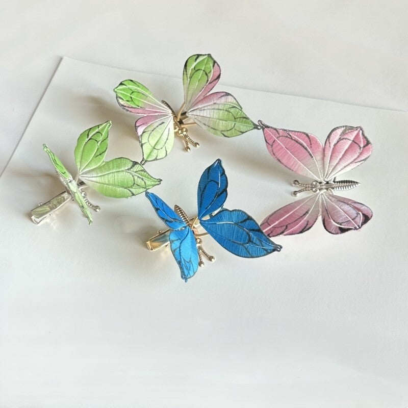 Flying butterfly hair clips handmade with Chanhua DIY kit, featuring green, pink, and blue wire flower designs.