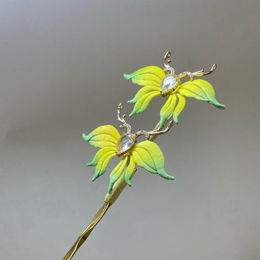 Handmade Chanhua deer floral hair pin with gradient yellow-green petals and crystal accents on a plain gray background