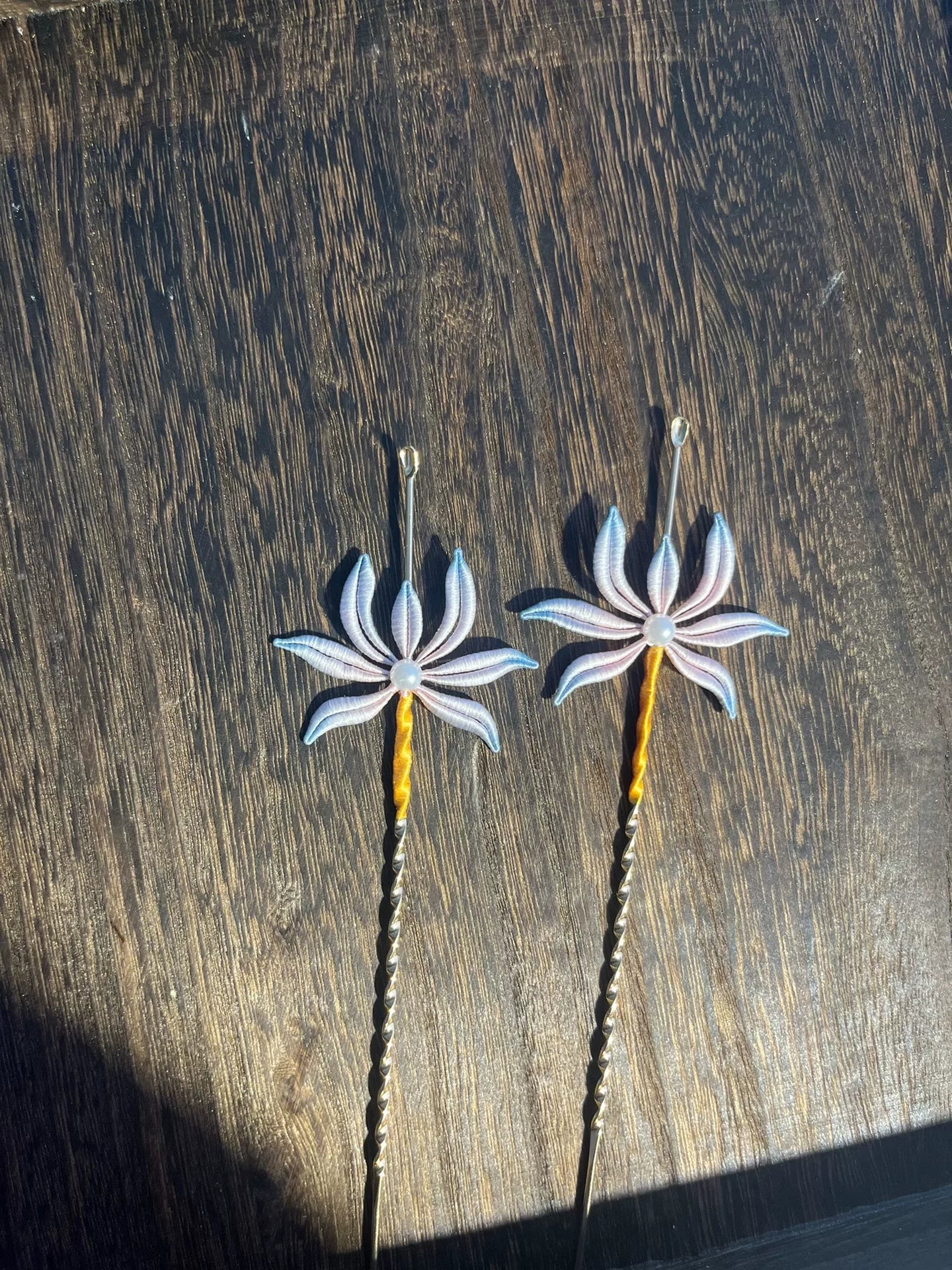 Two handmade Chanhua orchid - patterned ear - pick hairpins held by a hand-4