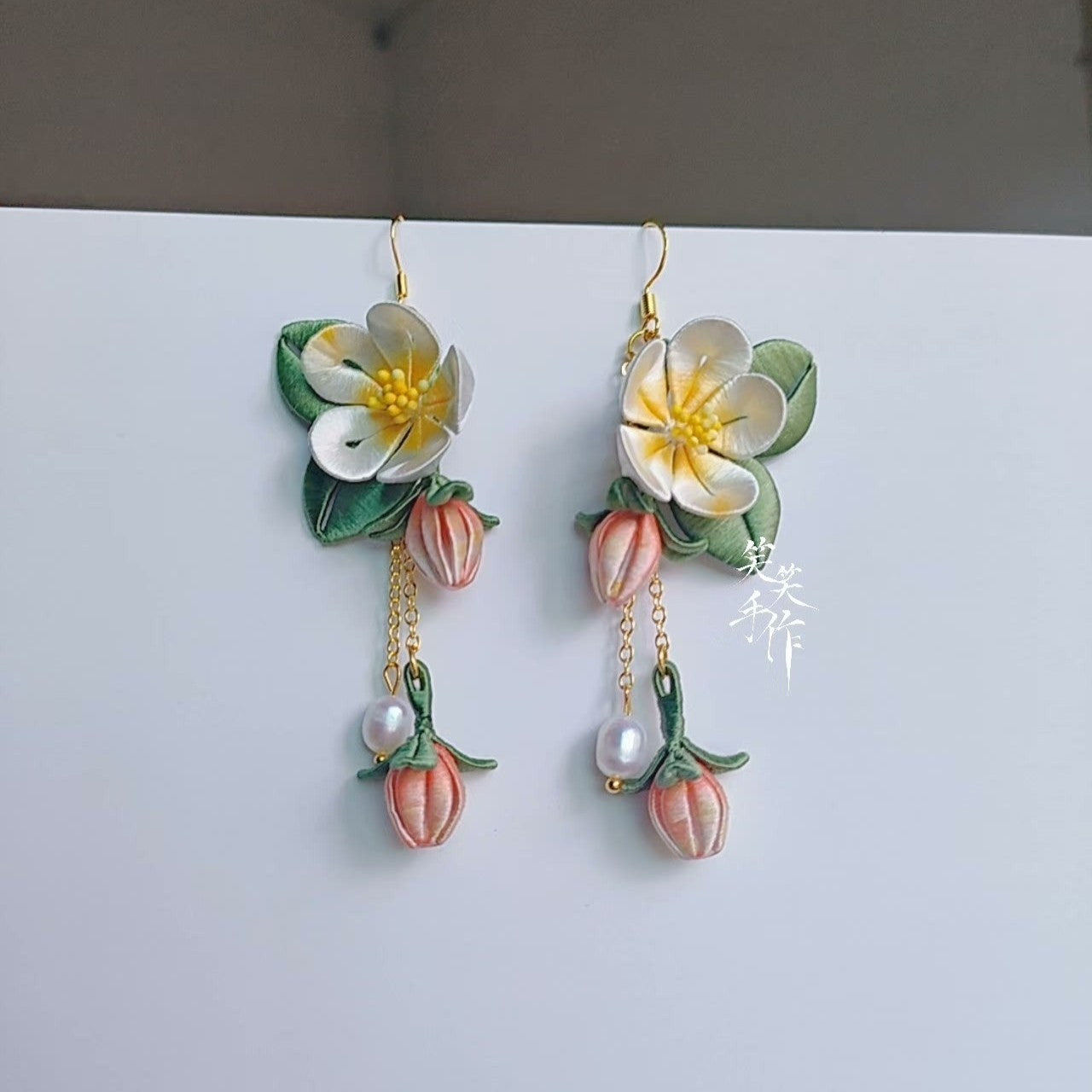 Full view of elegant handmade Camellia flower earrings with dangling pearl and bud accents, ideal for daily wear or formal events, displayed on a clean white surface.