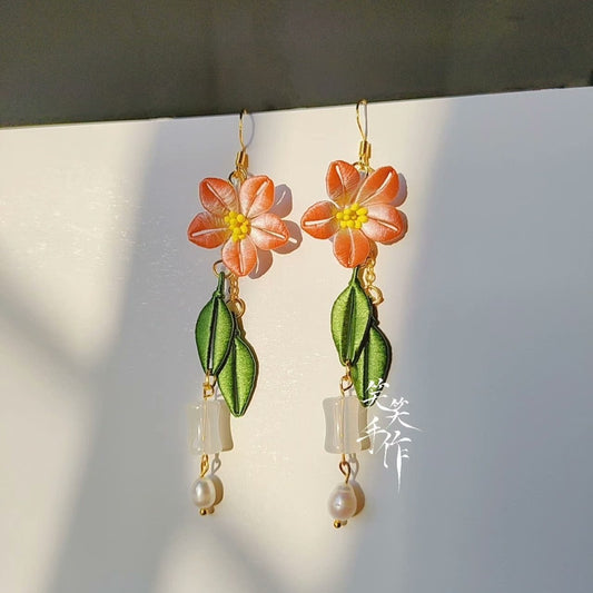 Pair of elegant Chanhua flower earrings with 925 silver hooks, natural freshwater pearls, and clear white accents, displayed against a clean background with natural light.