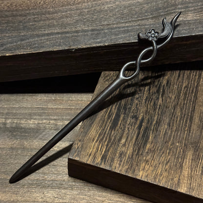 Natural African Blackwood hair stick with 18cm secluded orchid carved design on wooden background.