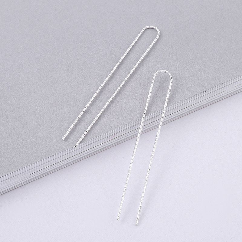 Two silver-tone U-shaped hairpin blanks for DIY jewelry making, laid on a grey surface.
