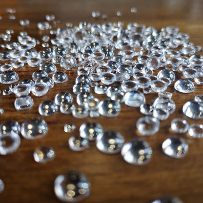 3-8mm flat back transparent acrylic dome cabochons on wooden surface for craft decoration
