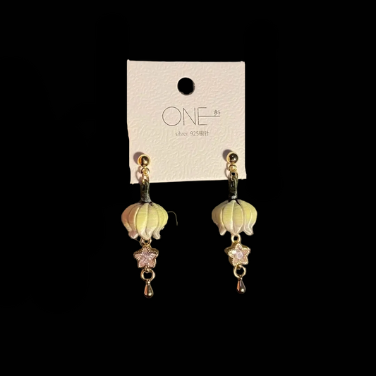 Handcrafted Chanhua earrings featuring pale yellow Lily of the Valley blossoms with star-shaped crystal dangles.