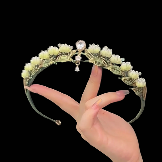 Handcrafted Lily of the Valley Chanhua tiara featuring pale yellow thread-wrapped flowers and green leaves with pearl drop accents.