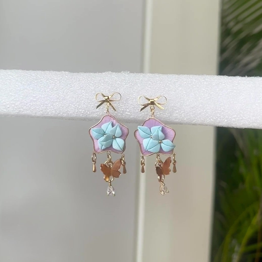 3D thread-wrapped floral drop earrings featuring a star motif and crystal accents made with traditional Chanhua techniques.