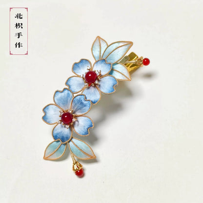 Handcrafted Ronghua blue cloisonné hair clip featuring two blue handmade silk flowers with golden edges and red bead centers.