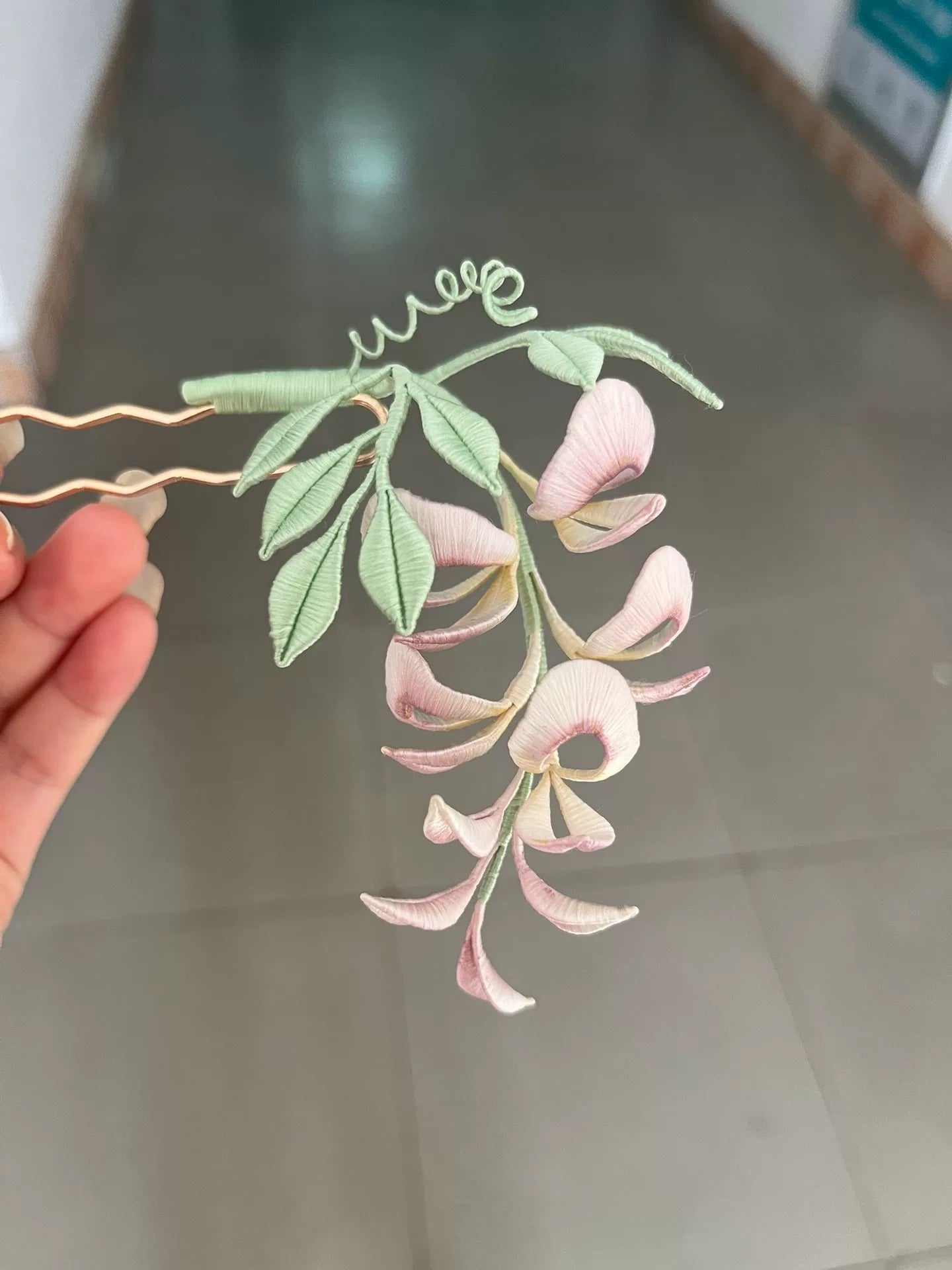 A handmade Chanhua wisteria flower accessory with pink petals and green leaves-4
