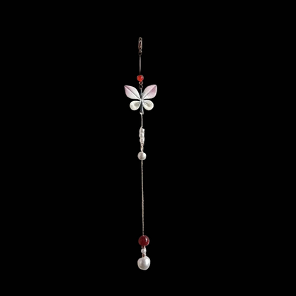 Handcrafted Chanhua thread-wrapped butterfly pendant with pink and white wings and a long gold chain tassel featuring pearl and red bead accents.