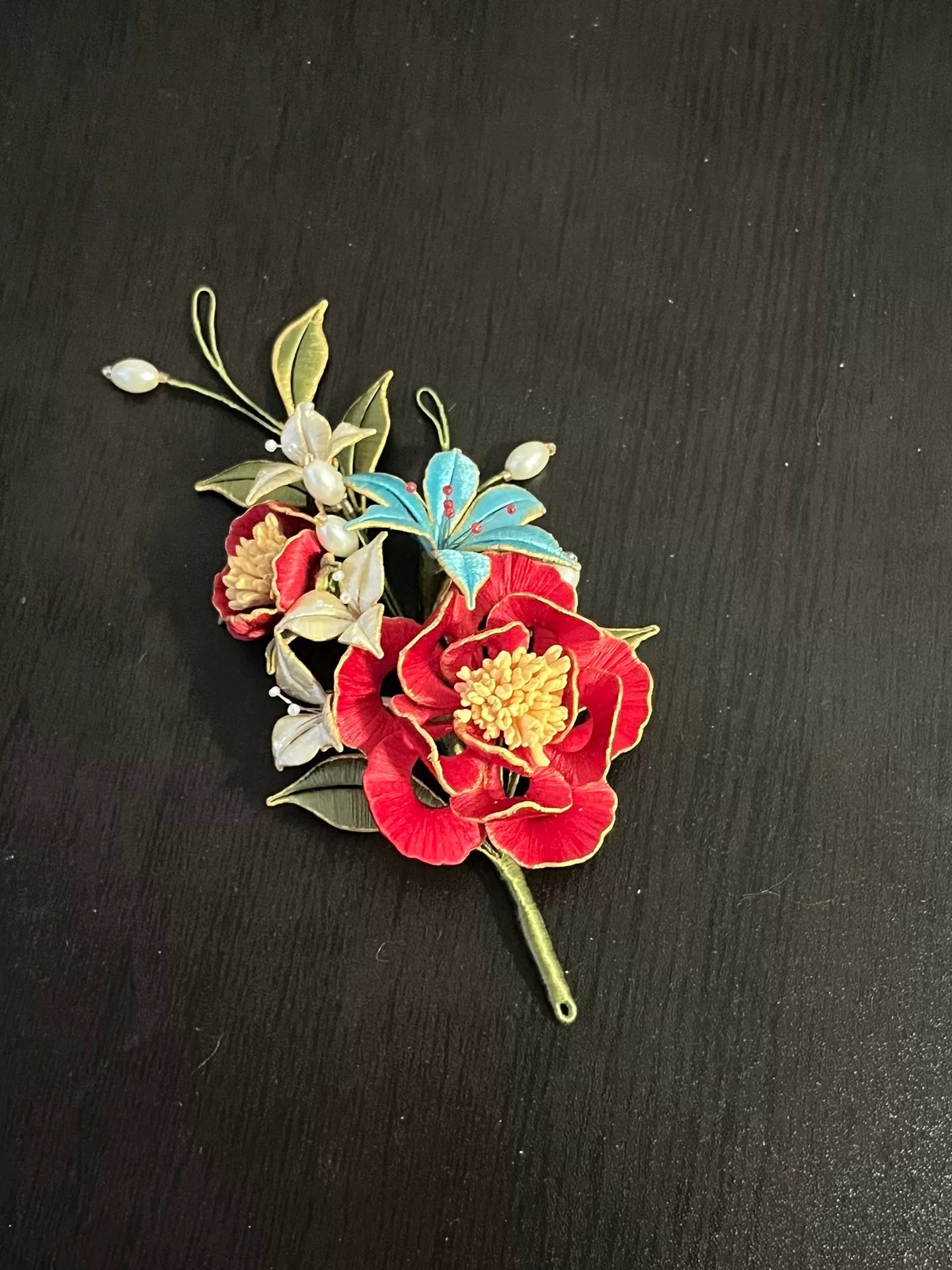 A handmade Chanhua hairpin and brooch with red flowers, green leaves, white flowers, a blue butterfly, and pearls