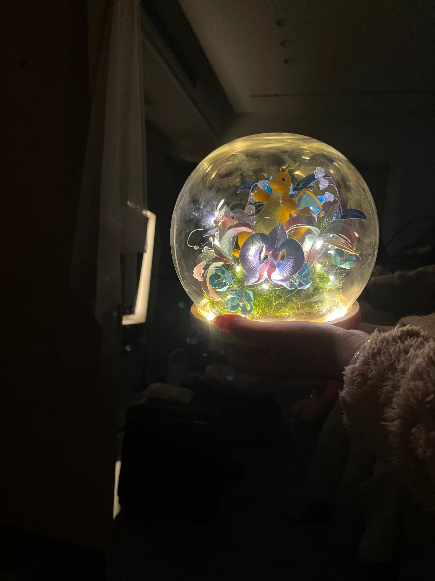 A person holding a handmade Chanhua DIY ornament with illuminated interior-2