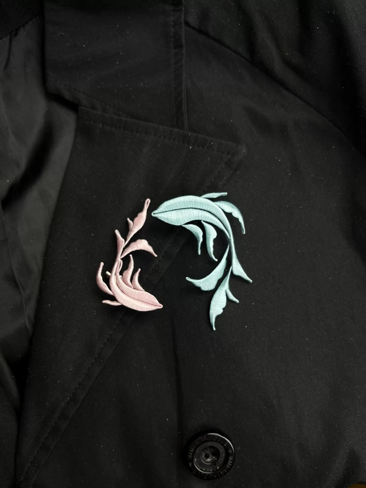 A handmade Chanhua Qiyu little fish brooch on a black coat-4