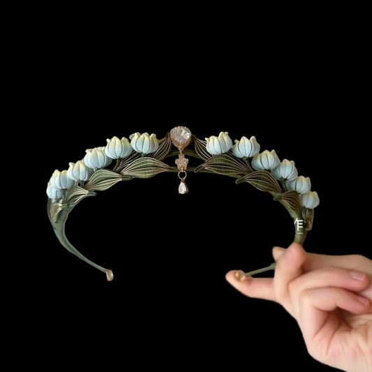 Handcrafted Lily of the Valley Chanhua crown featuring light blue thread-wrapped flowers and green leaves with a central crystal pendant.