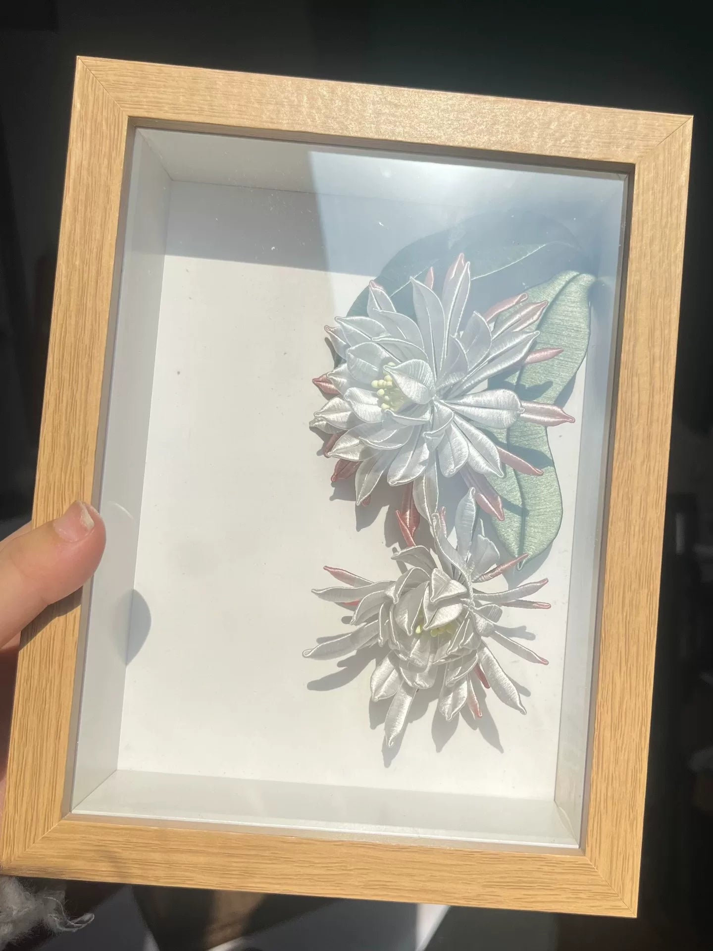 A handmade Chanhua table display in a wooden box with white and pink petals and green leaves-6