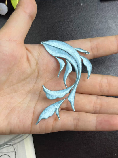 A handmade Chanhua Qiyu little fish brooch on a black coat-3
