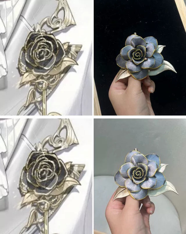 Handmade Chanhua brooch in blue and gold tones, held by a hand