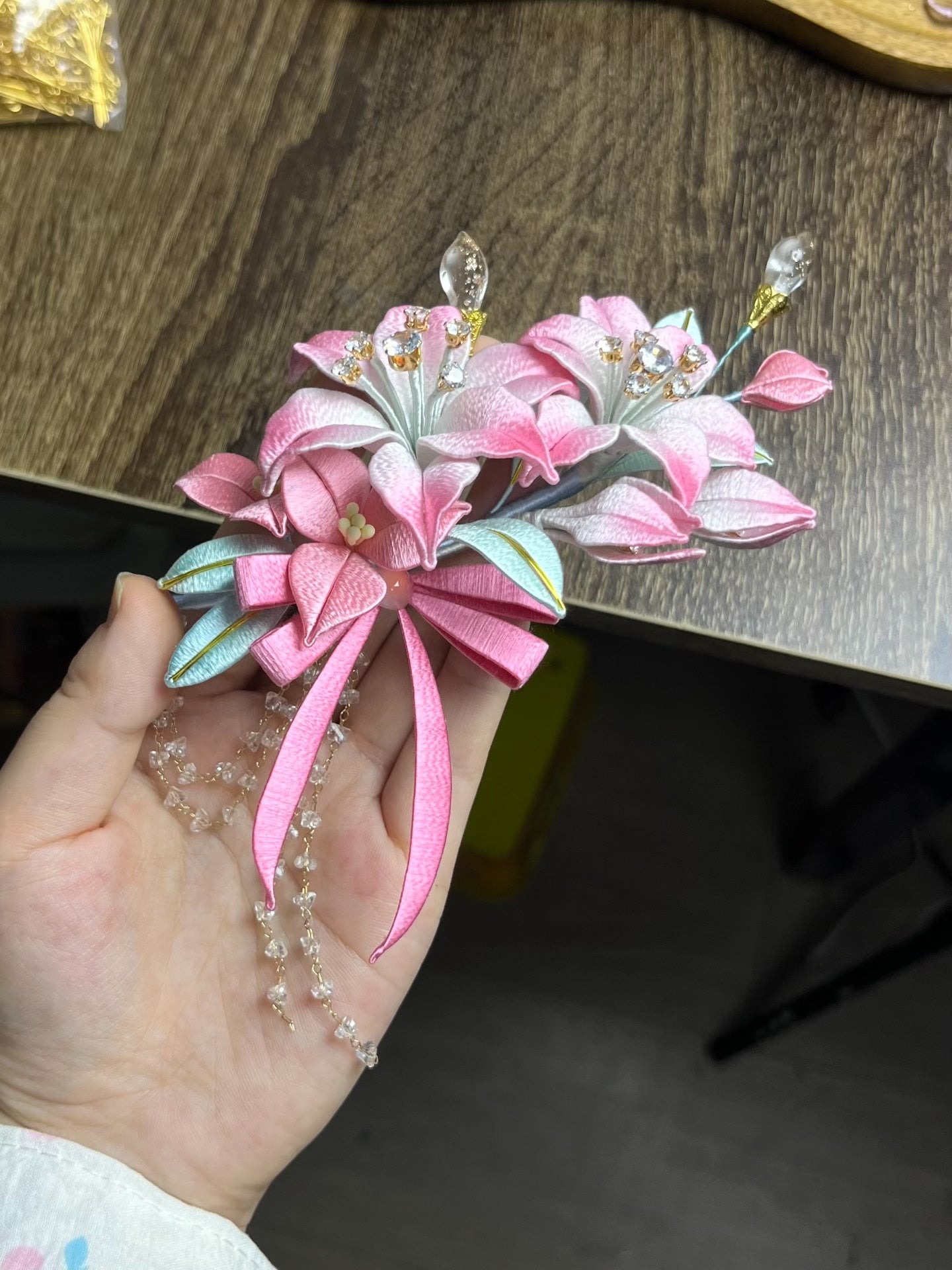 A handmade Chanhua lily hairpiece in pink with leaves and dangling chains on black hair-5