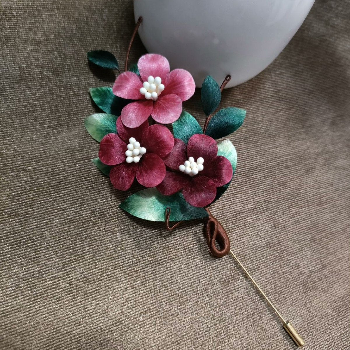 Handmade Ronghua three flower velvet brooch in pink and red with natural mulberry silk, white bead centers, and green leaves