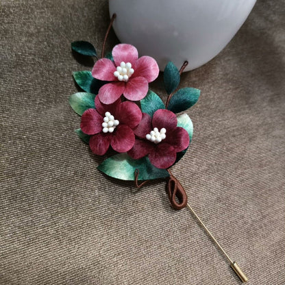 Handmade Ronghua three flower velvet brooch in pink and red with natural mulberry silk, white bead centers, and green leaves