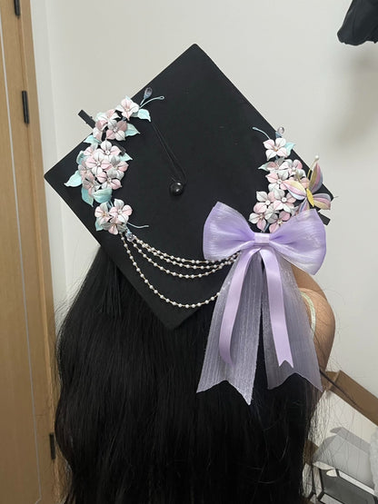 A black graduation cap adorned with handmade Chanhua hydrangea, butterfly, and a lavender bow-2