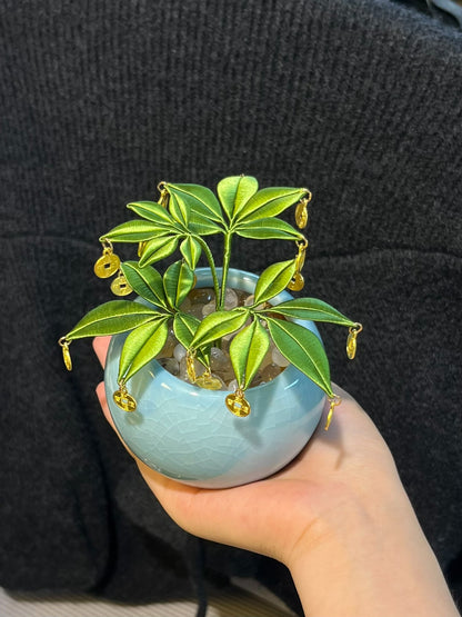A handmade Chanhua money tree ornament in a light - blue pot with green leaves and golden coins