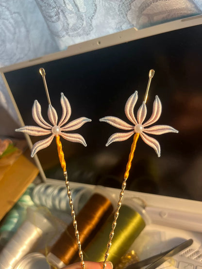 Two handmade Chanhua orchid - patterned ear - pick hairpins held by a hand-3