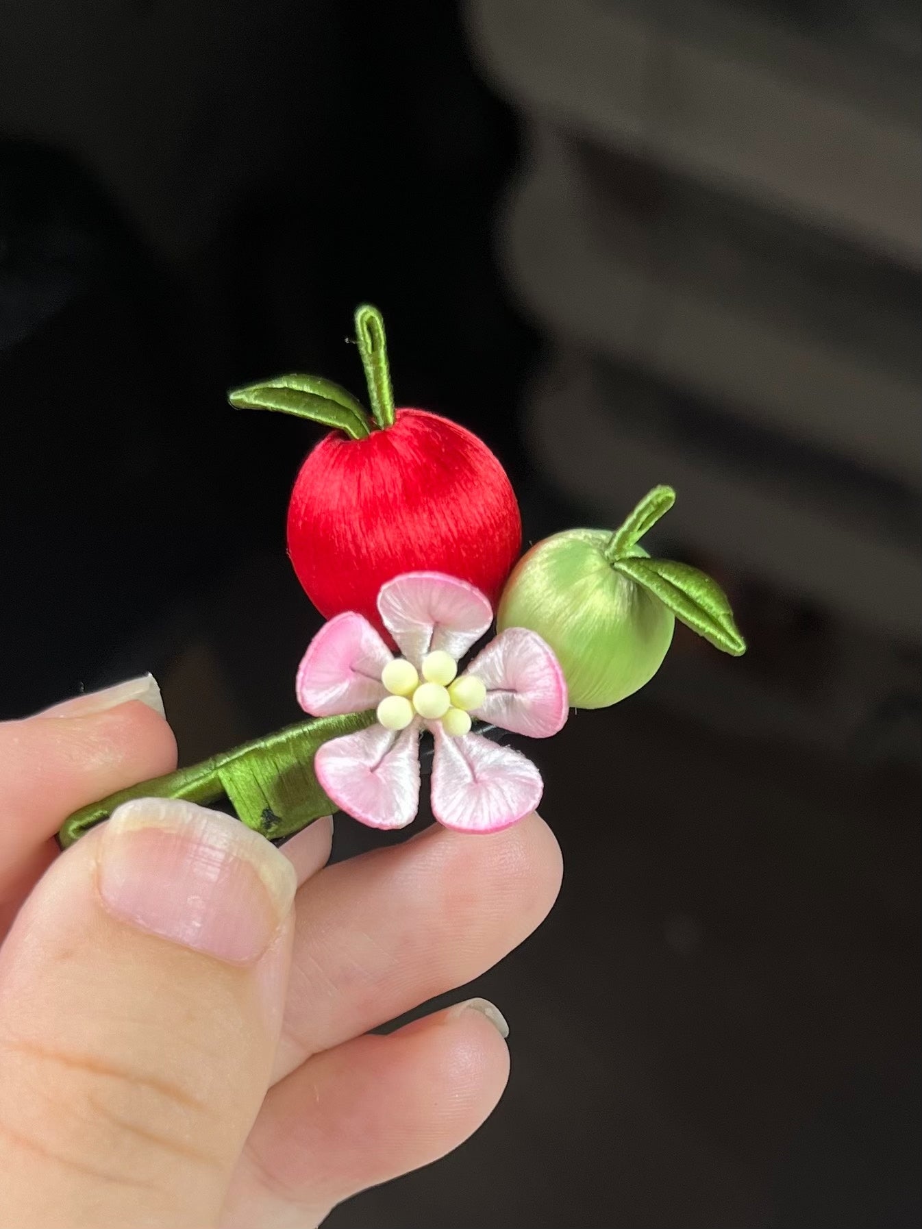 A hair clip with red and green apples and a pink flower on black hair-2