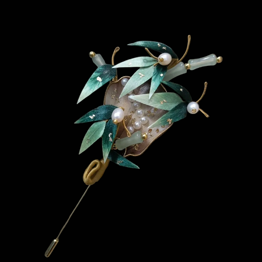 Close-up of green silk velvet bamboo leaves with gold details and pearls on Ronghua fan brooch