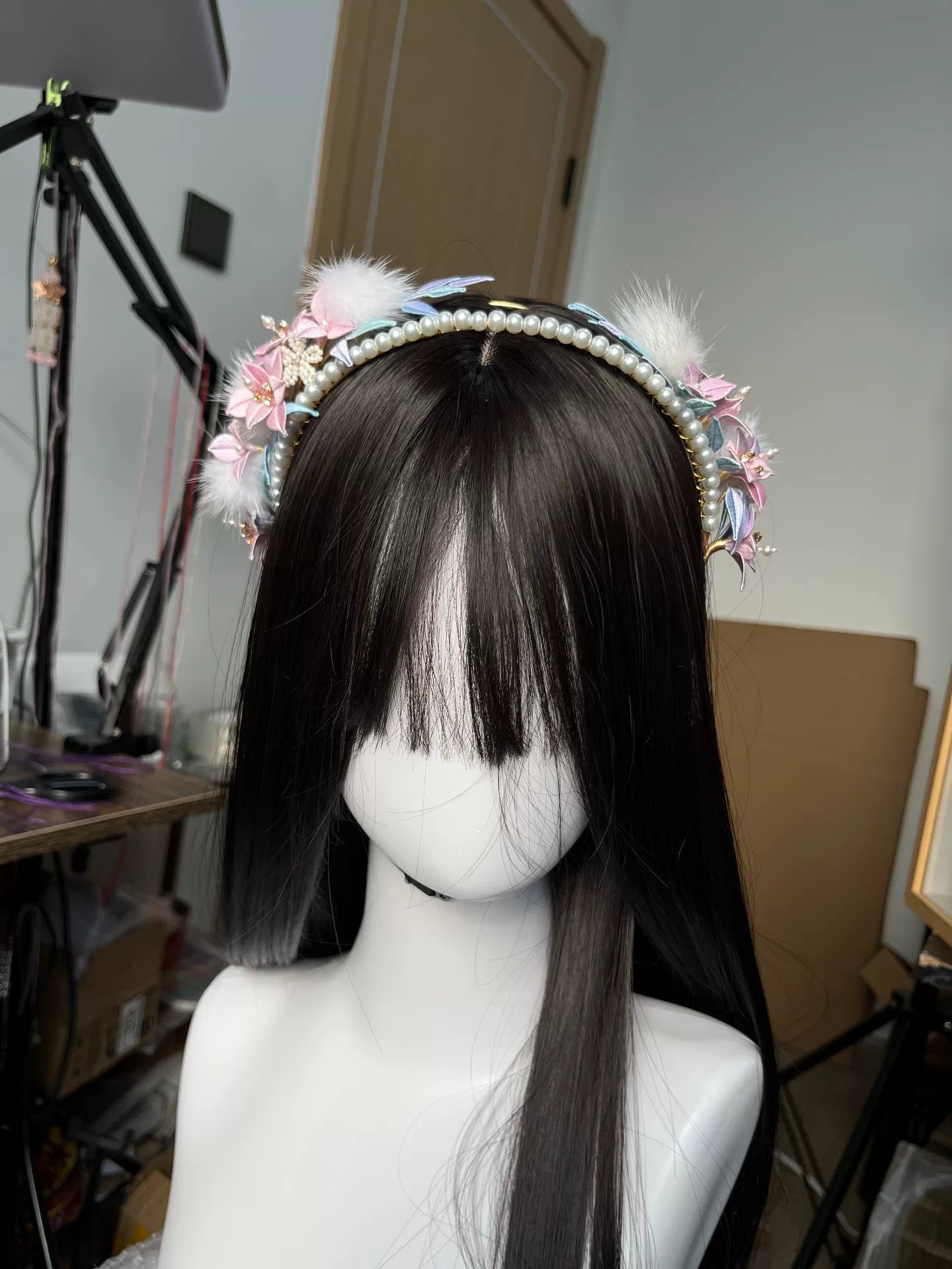 A handmade Chanhua orchid headband with pink flowers, white feathers, and pearls on a mannequin's head-3
