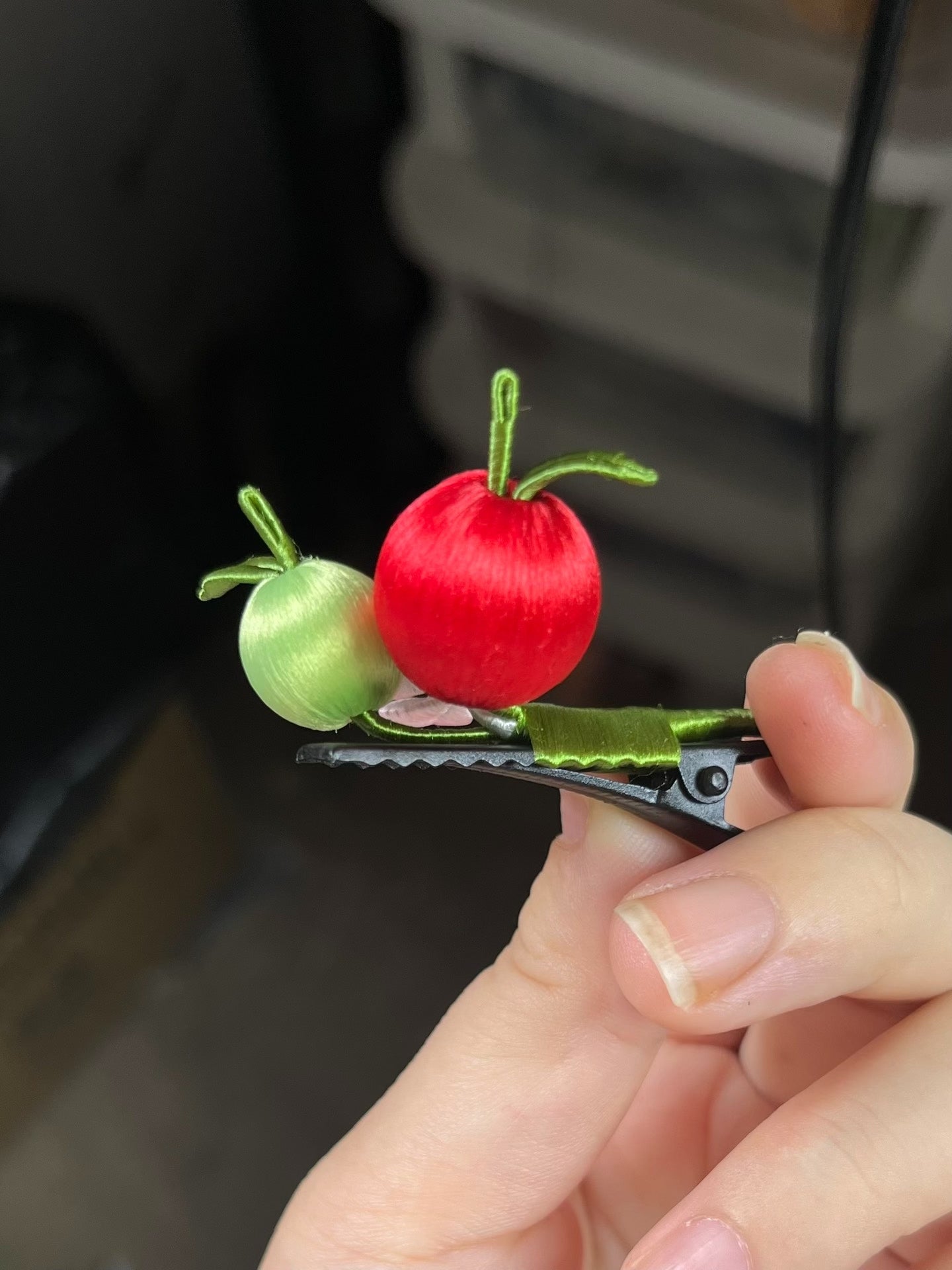 A hair clip with red and green apples and a pink flower on black hair-4