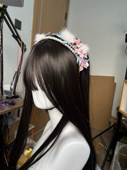 A handmade Chanhua orchid headband with pink flowers, white feathers, and pearls on a mannequin's head