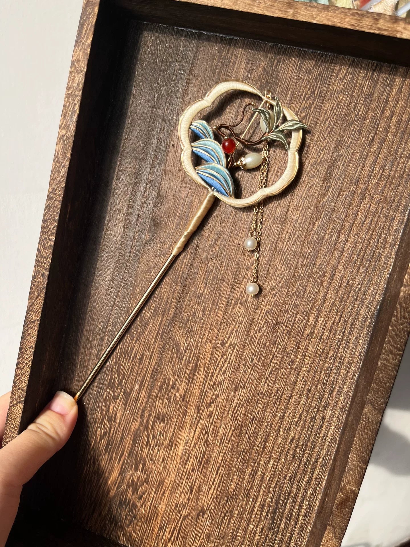 A handmade Chanhua fan - shaped hairpin with blue and white patterns, red and white beads, and pearl chain