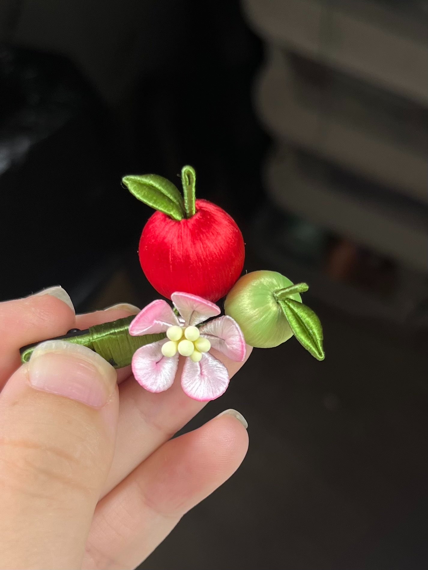 A hair clip with red and green apples and a pink flower on black hair-5
