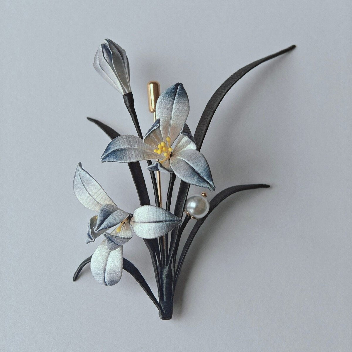 Handcrafted Chanhua orchid brooch featuring ink-wash style grey and white thread-wrapped petals with a pearl accent.