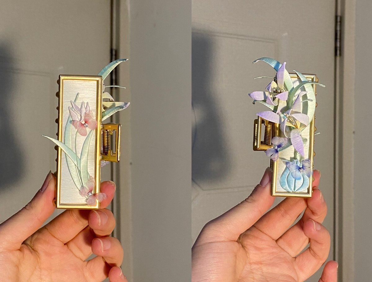 Hand holding handmade Chanhua double sided orchid hair claw showing both sides of the detailed floral design