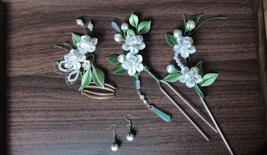 A set of handmade Chanhua jasmine - themed hair accessories in a wooden tray-2