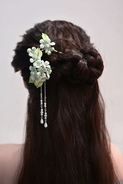 A woman wearing a handmade Chanhua silk hydrangea hairpin with beaded tassels