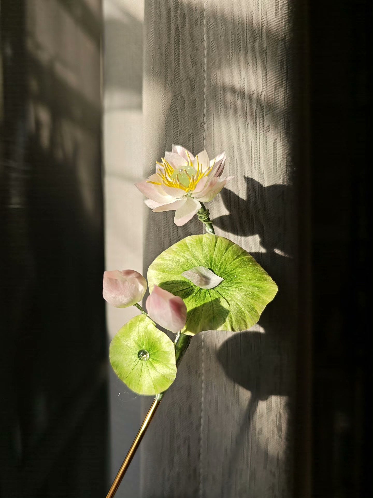 A handmade Ronghua lotus hairpin with a blooming lotus flower and green leaves