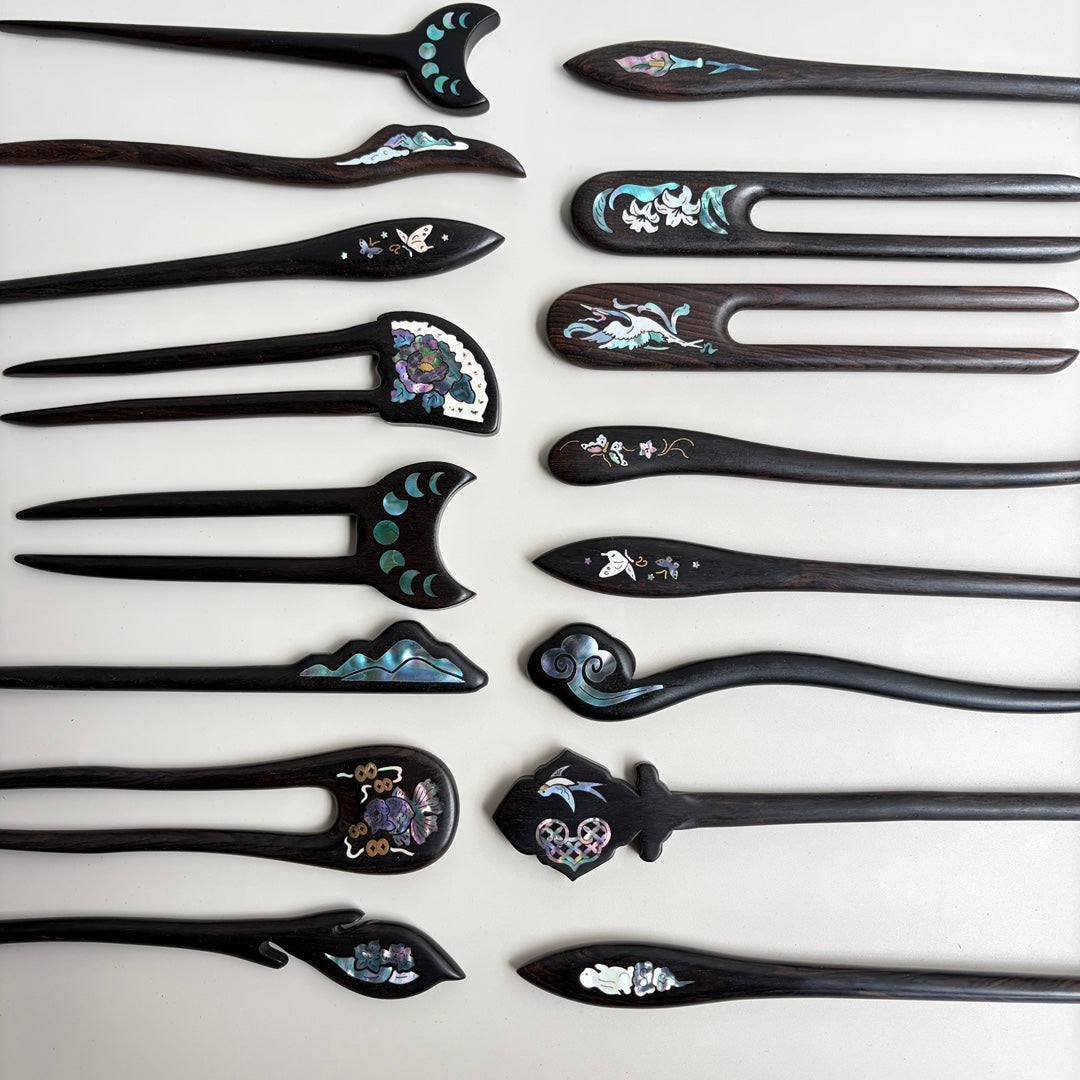 Handmade African Blackwood hair stick with curved top and blue mother-of-pearl inlay.