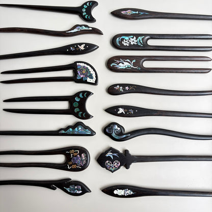 Handmade African Blackwood hair stick with curved top and blue mother-of-pearl inlay.