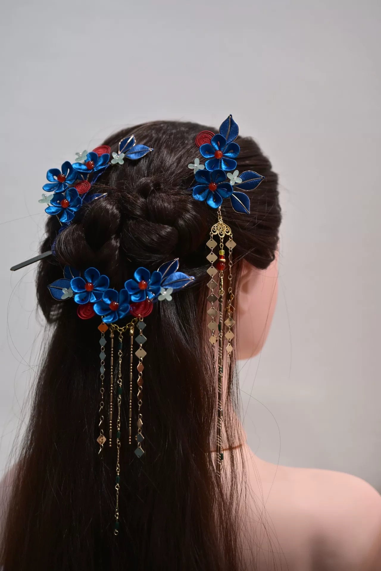 A woman wearing a handmade Chanhua imitation Diancui hair set with colorful flowers and tassels