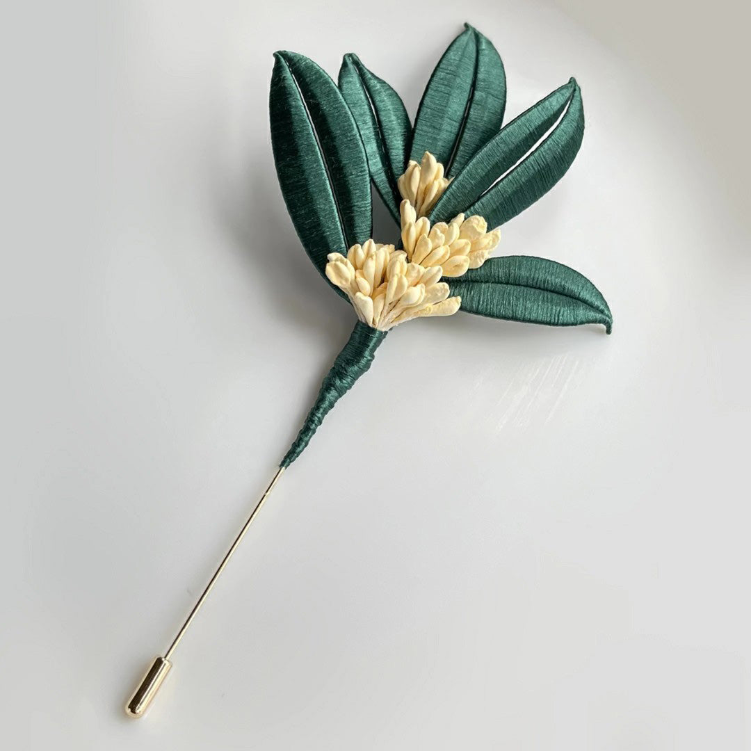 Handmade DIY Osmanthus brooch with green silk leaves and cream flowers, a Chanhua textile craft project with video tutorial.
