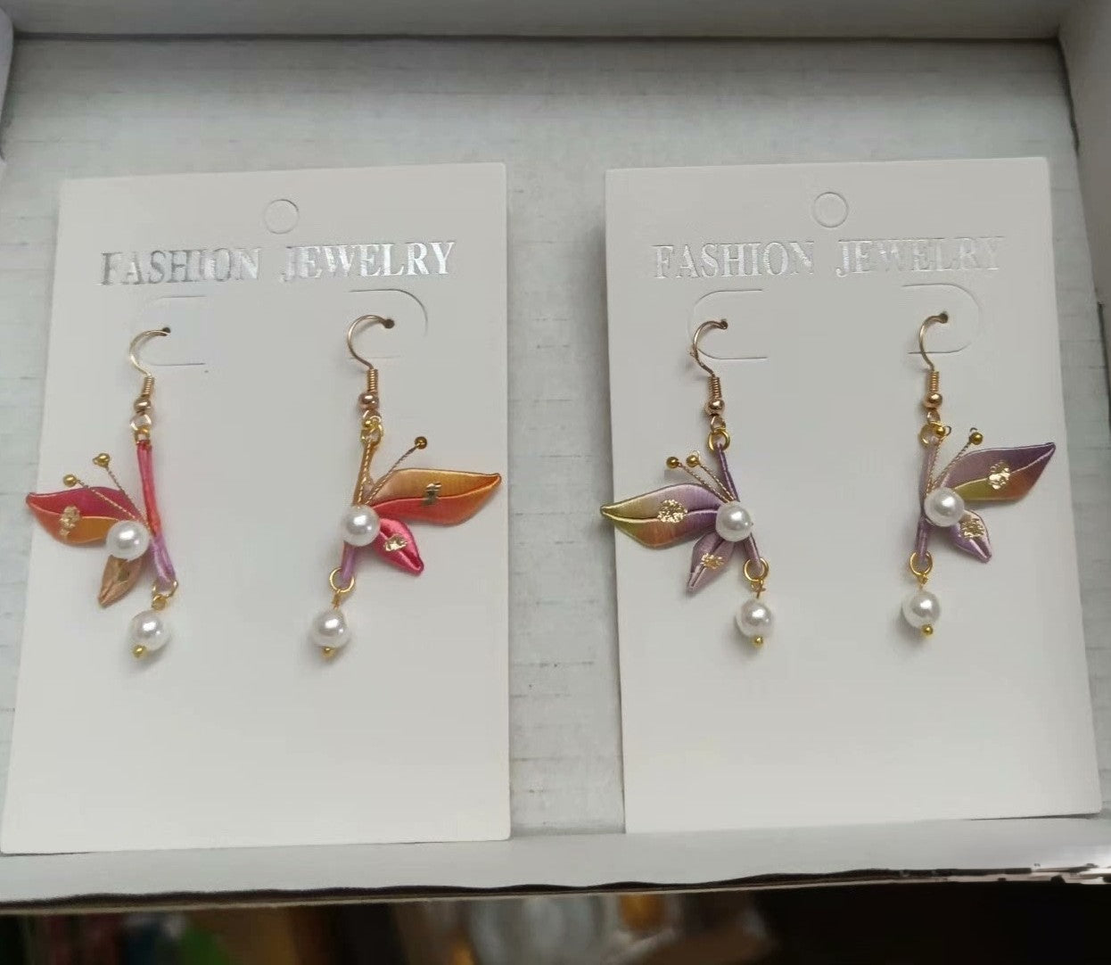 Colorful set of Chanhua butterfly earrings featuring orange, red, and purple ombre silk wings.