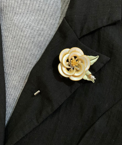 Chanhua handmade white camellia brooch with gold edge petals and yellow stamens, pinned on a black blazer lapel