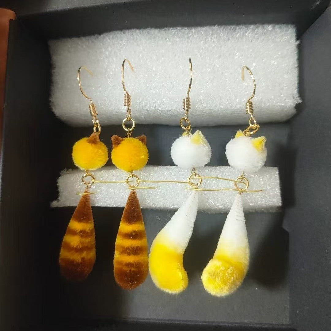 Handmade Ronghua little raccoon dangle earrings in yellow and brown mulberry silk velvet with gold hooks, displayed in clear box